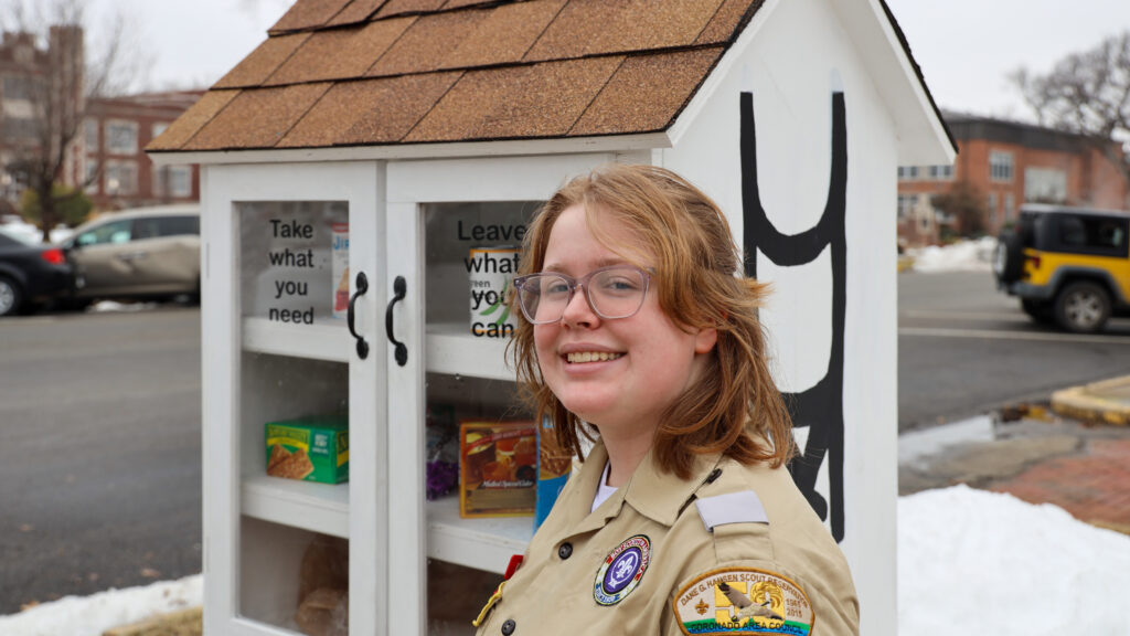 Young woman standing in front of outdoor pantry