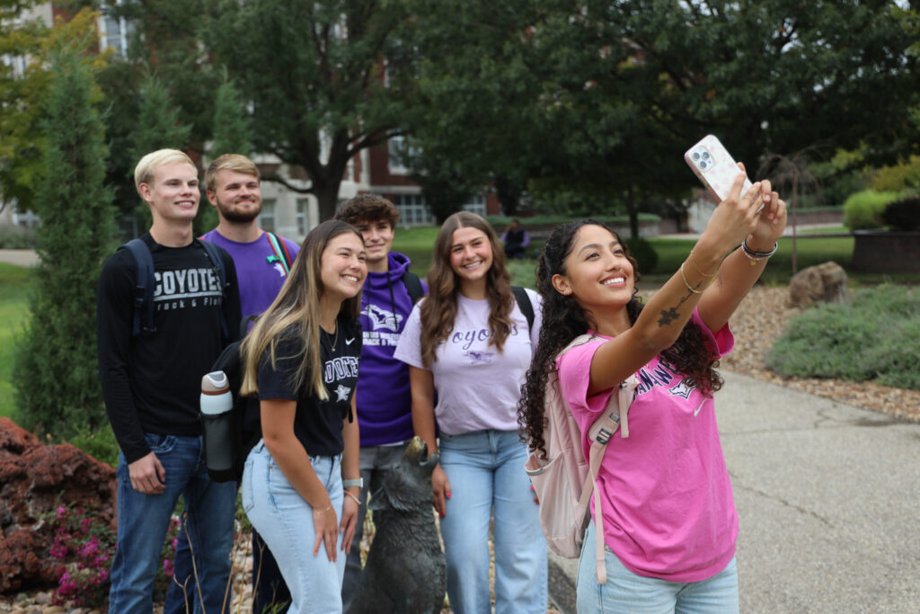 Group of students taking selfie near Coyote statue