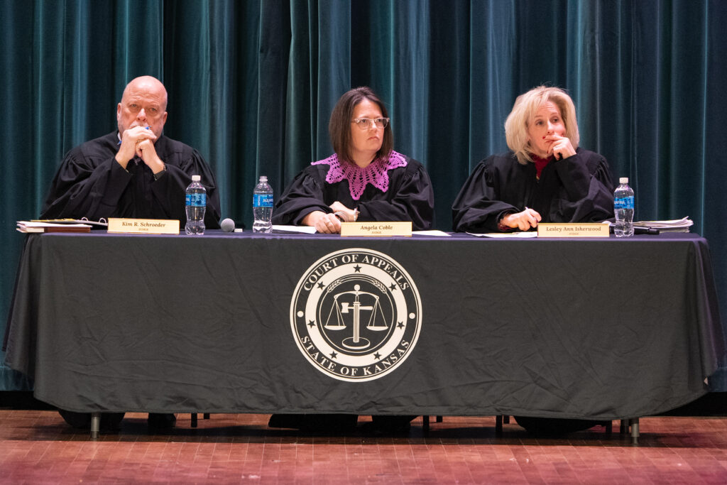 Three judges in robes at table