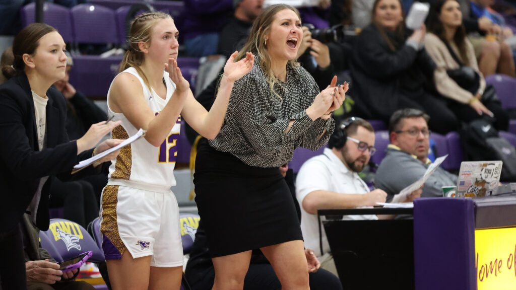 Women's basketball coach cheering on sideline
