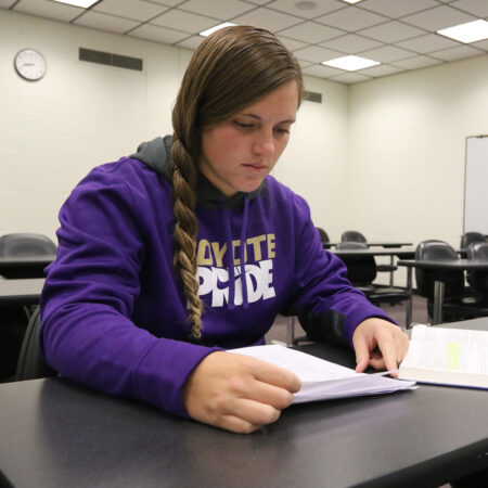 Student reading a book in class