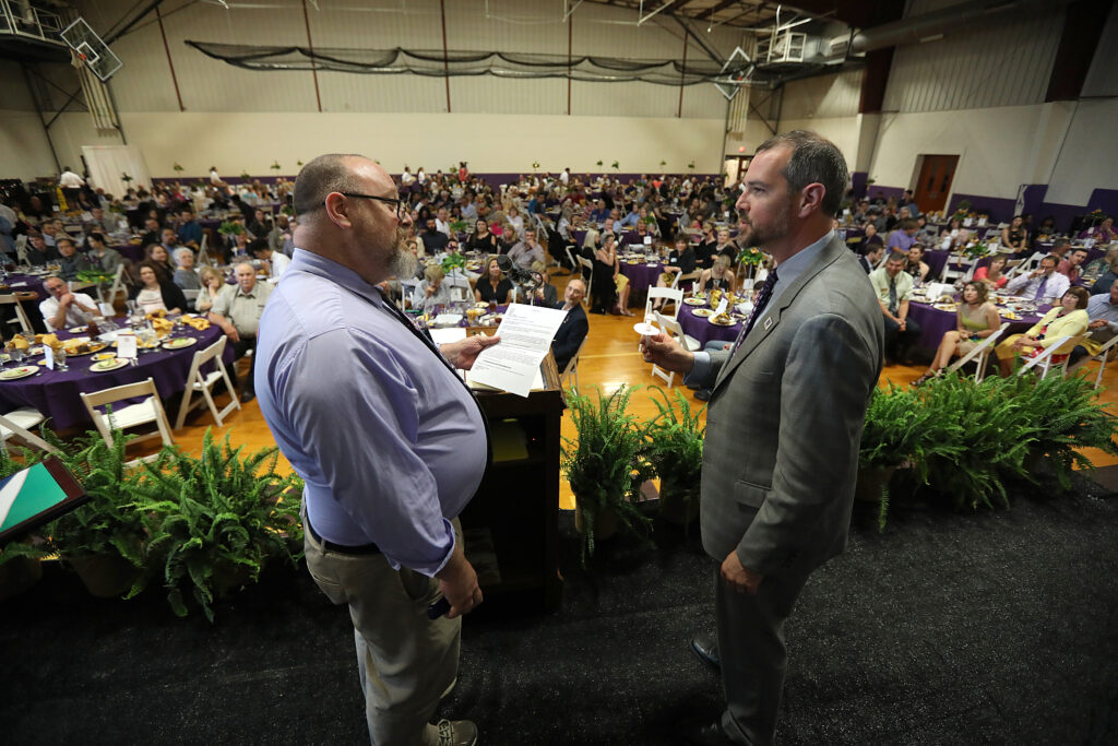 Two men in front of large crowd