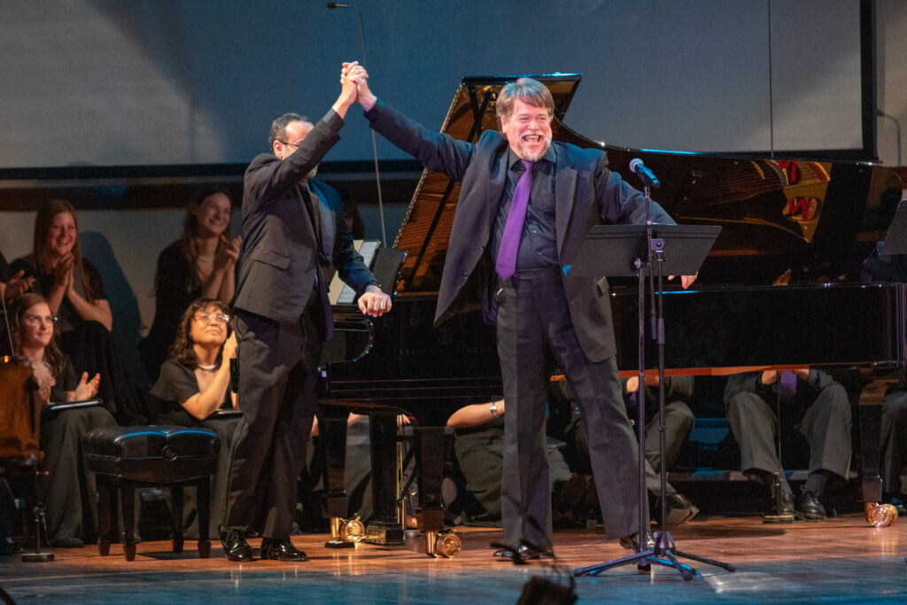 Men raising hands after operatic song