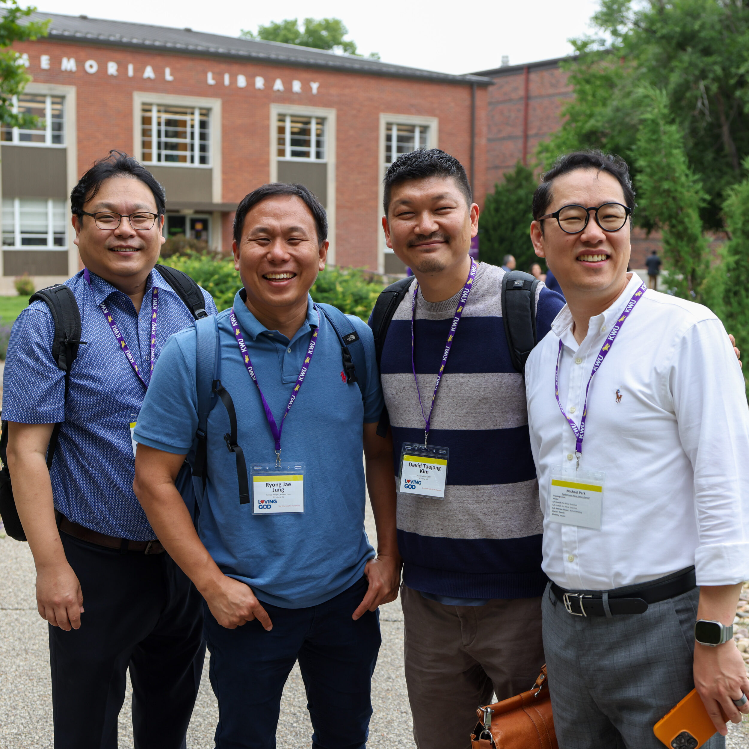 Four men standing outside in conference attire