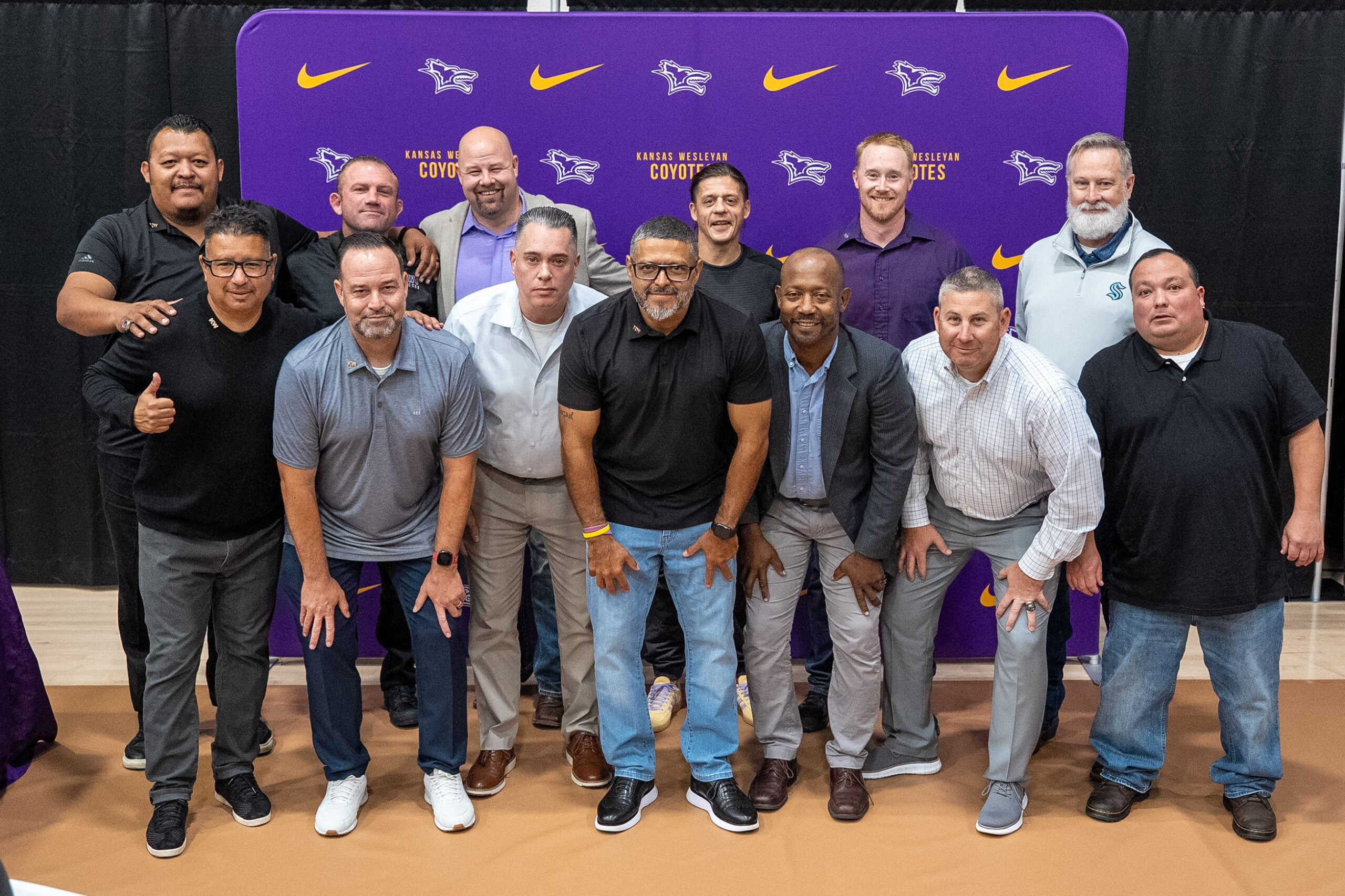 Group of men posing in front of backdrop