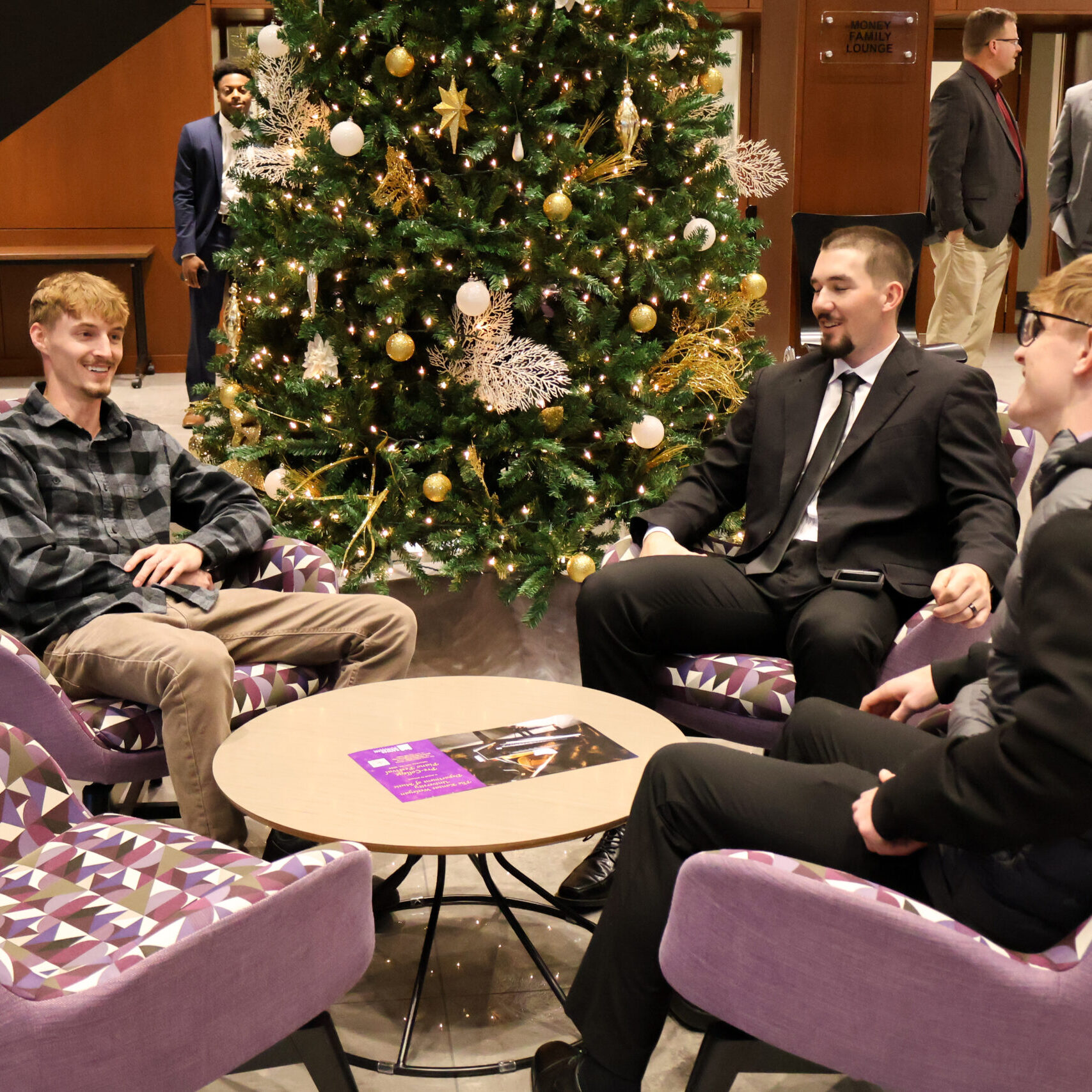 Various individuals sitting in chairs at fall graduation