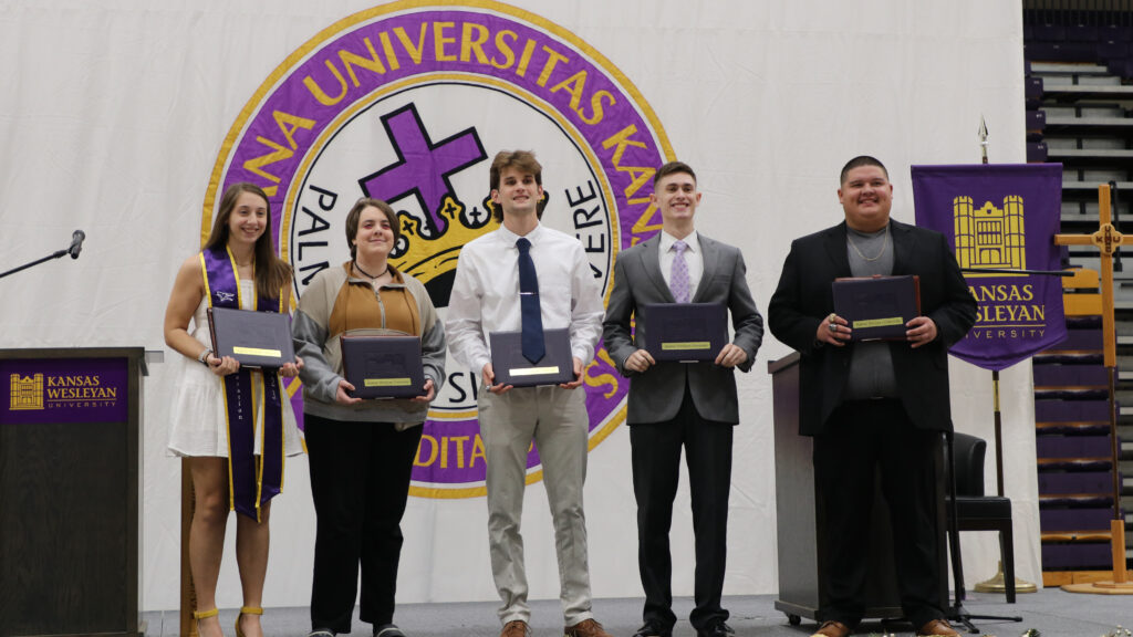 Fall 2023 graduates pose with their diplomas.