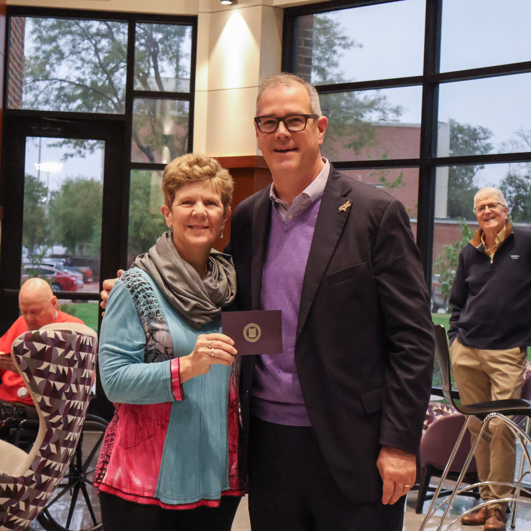 Man standing by woman with award
