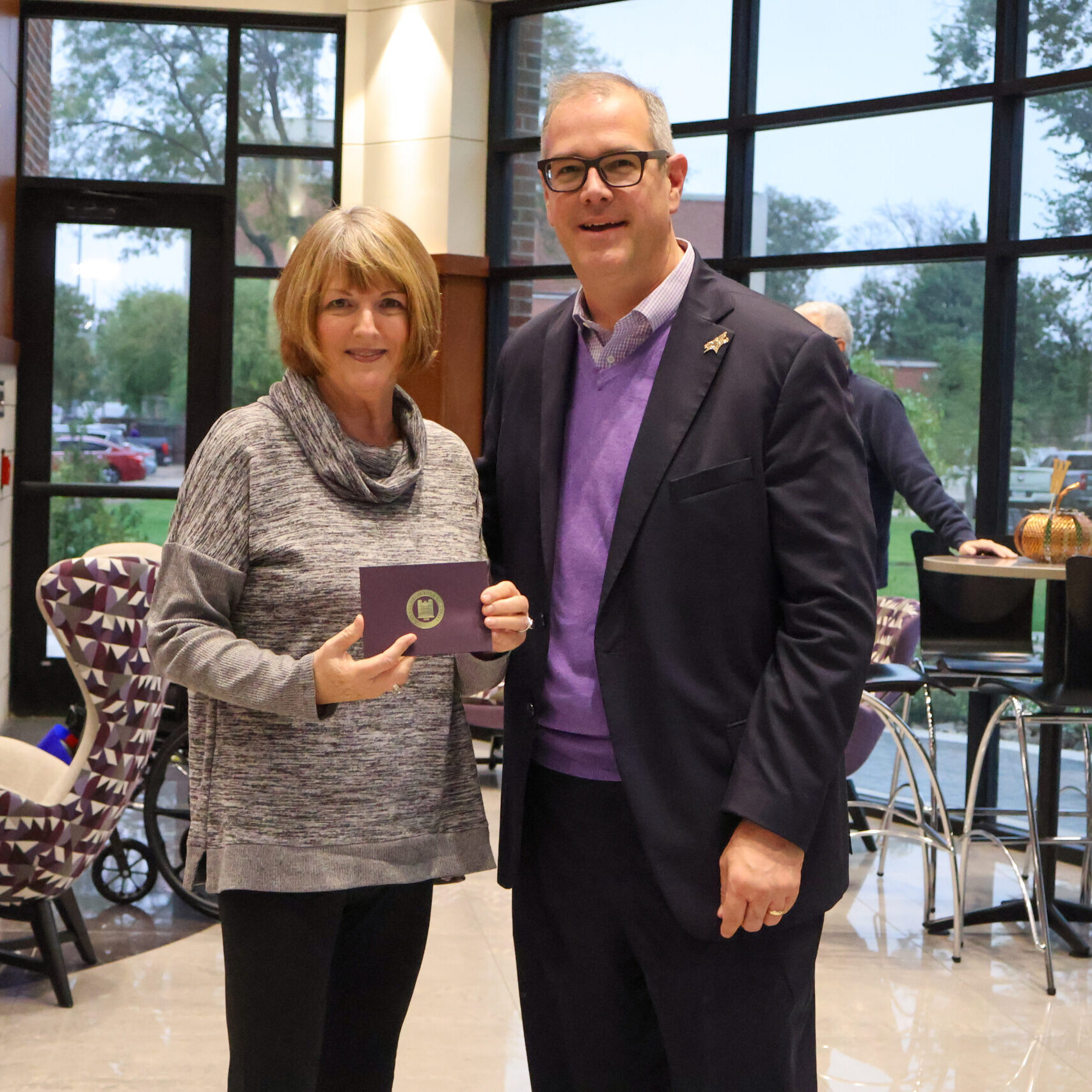 Man standing by woman with award