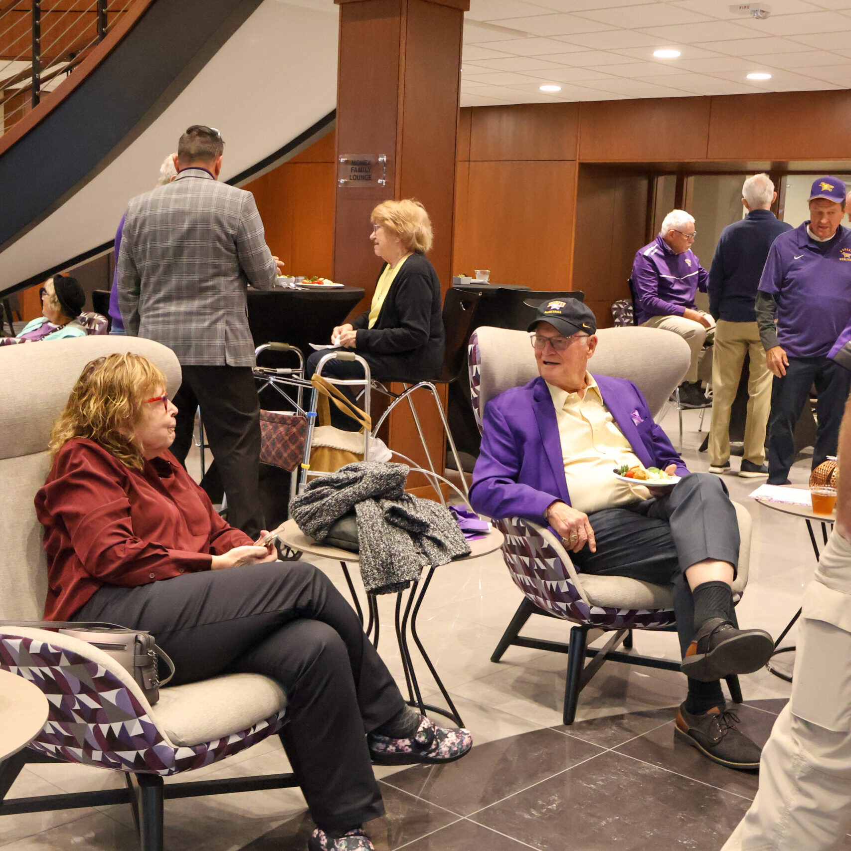 Large group of people talking, some seated, some standing