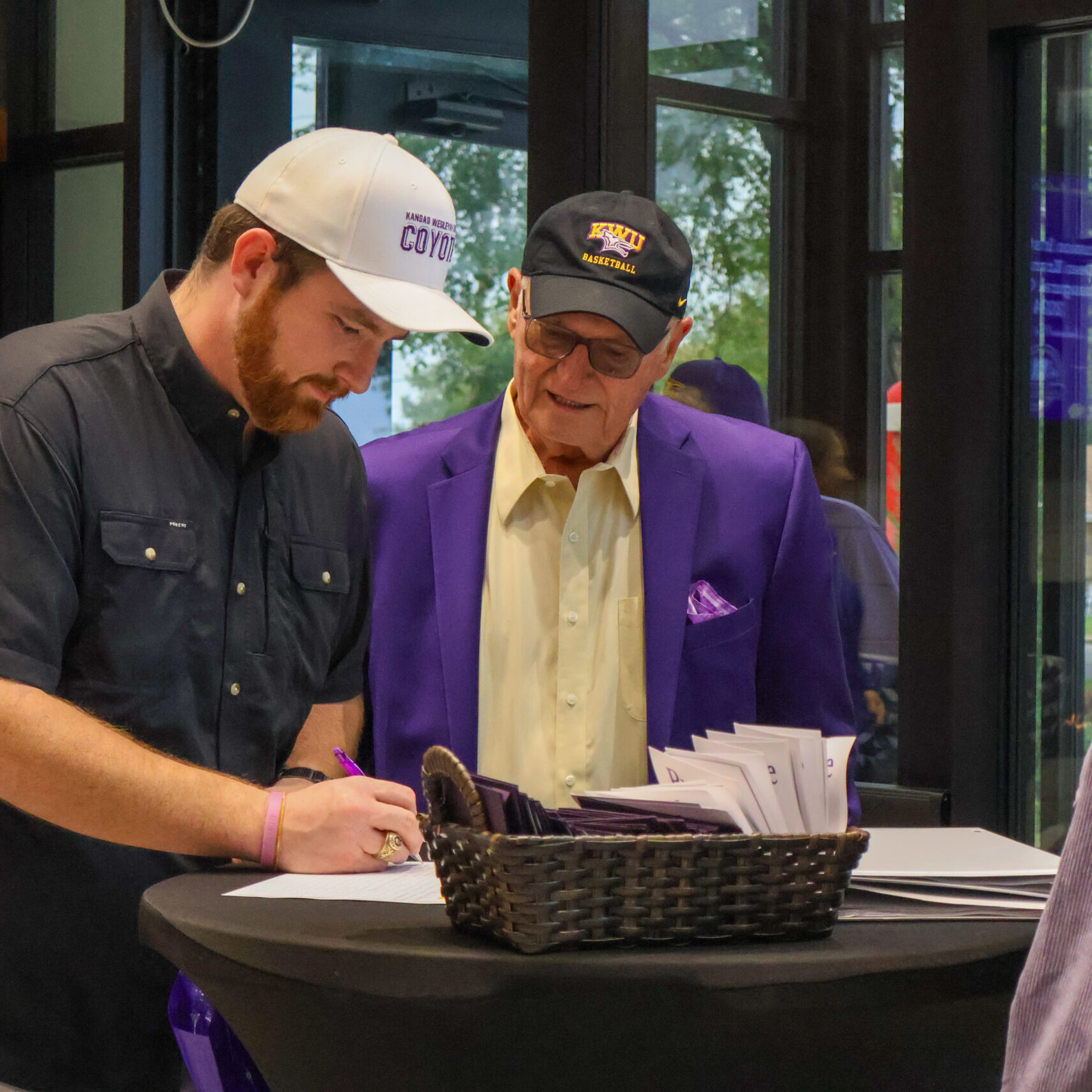 Two me leaning over table
