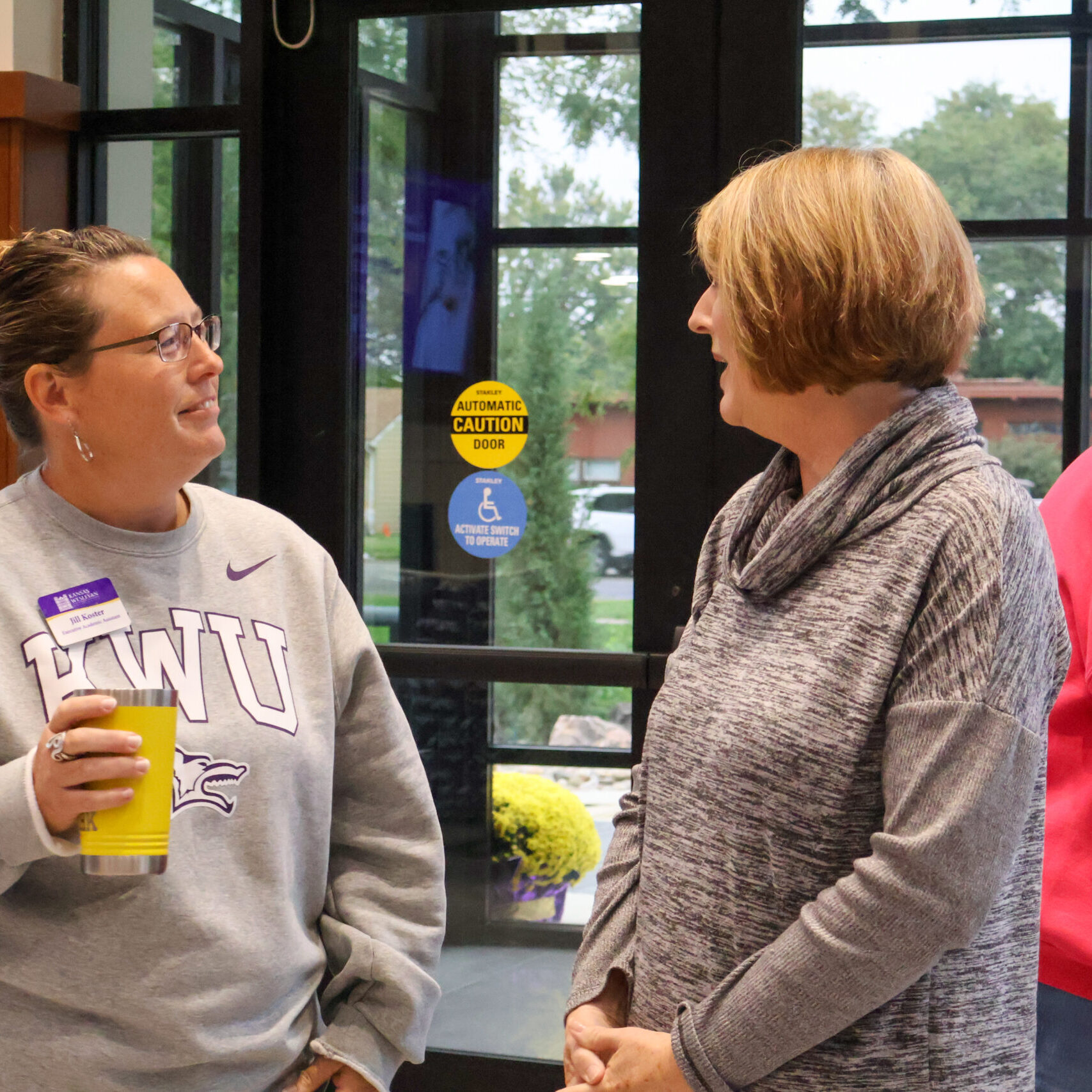 Two women standing next to each other talking