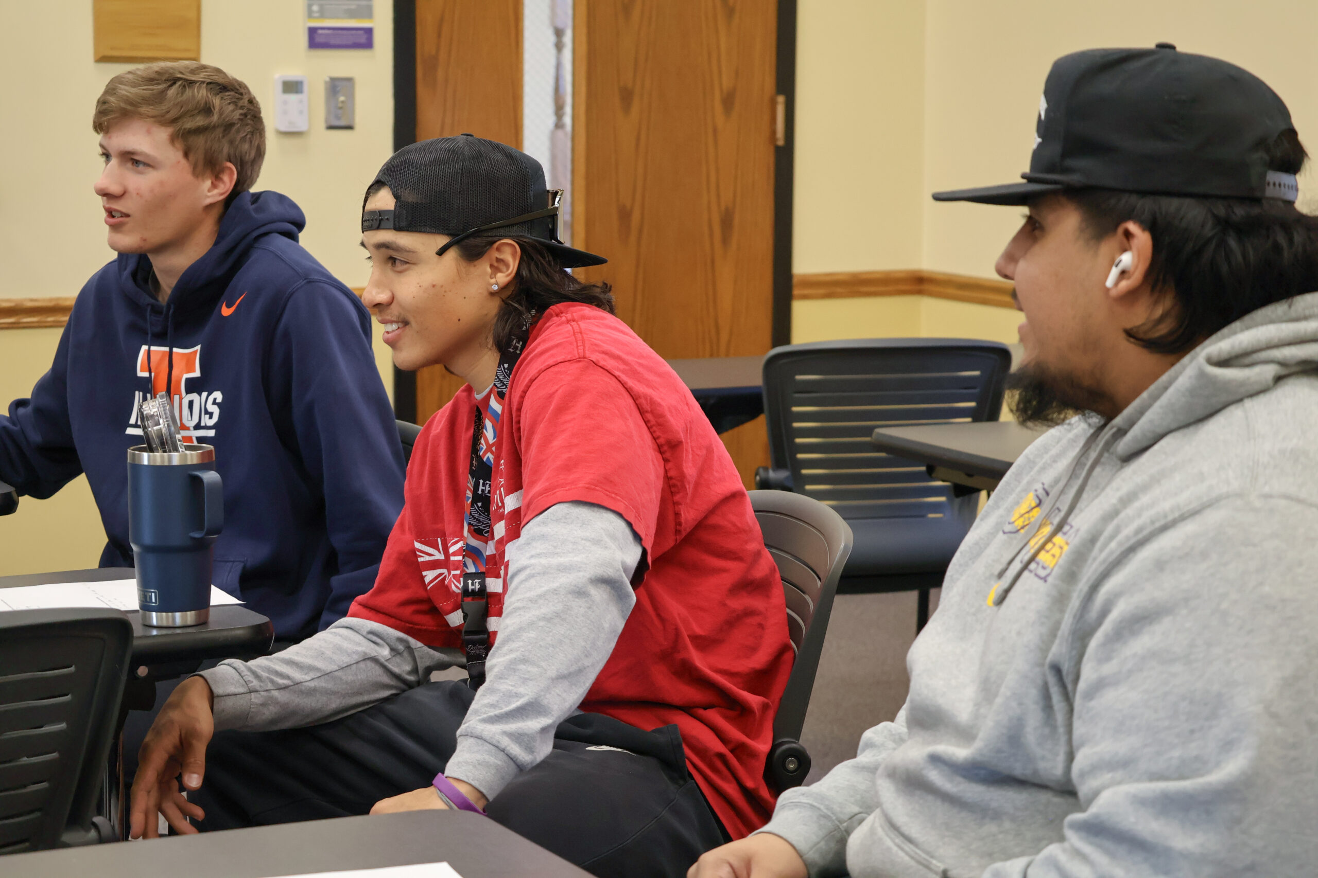 Three men in classroom listening
