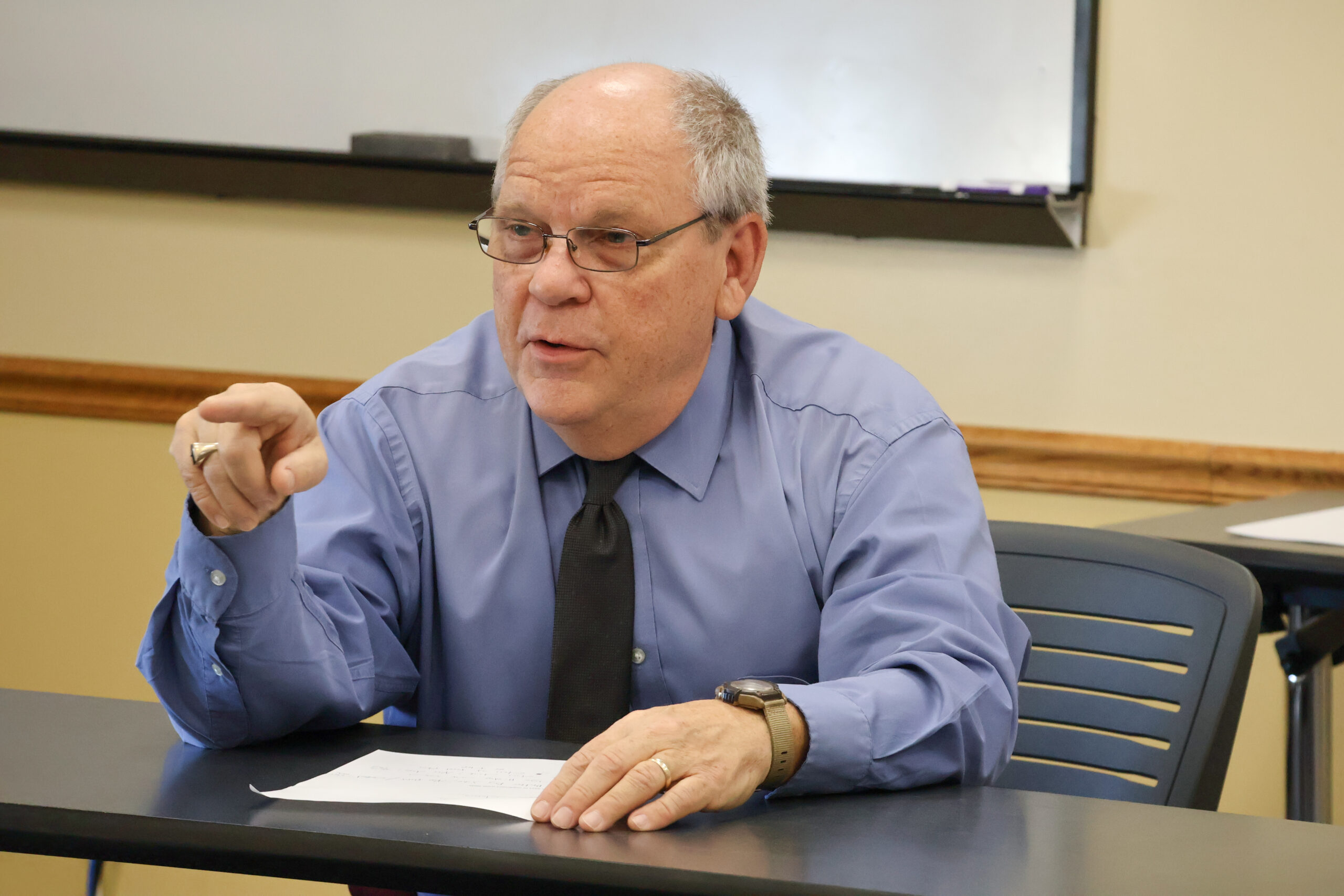 Man in shirt and tie pointing