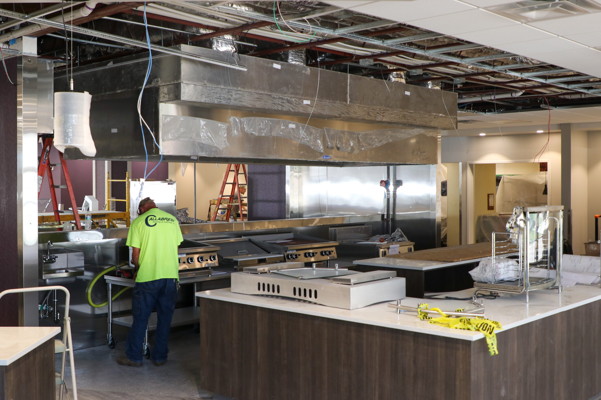 Men working indoors on construction, dining items around them