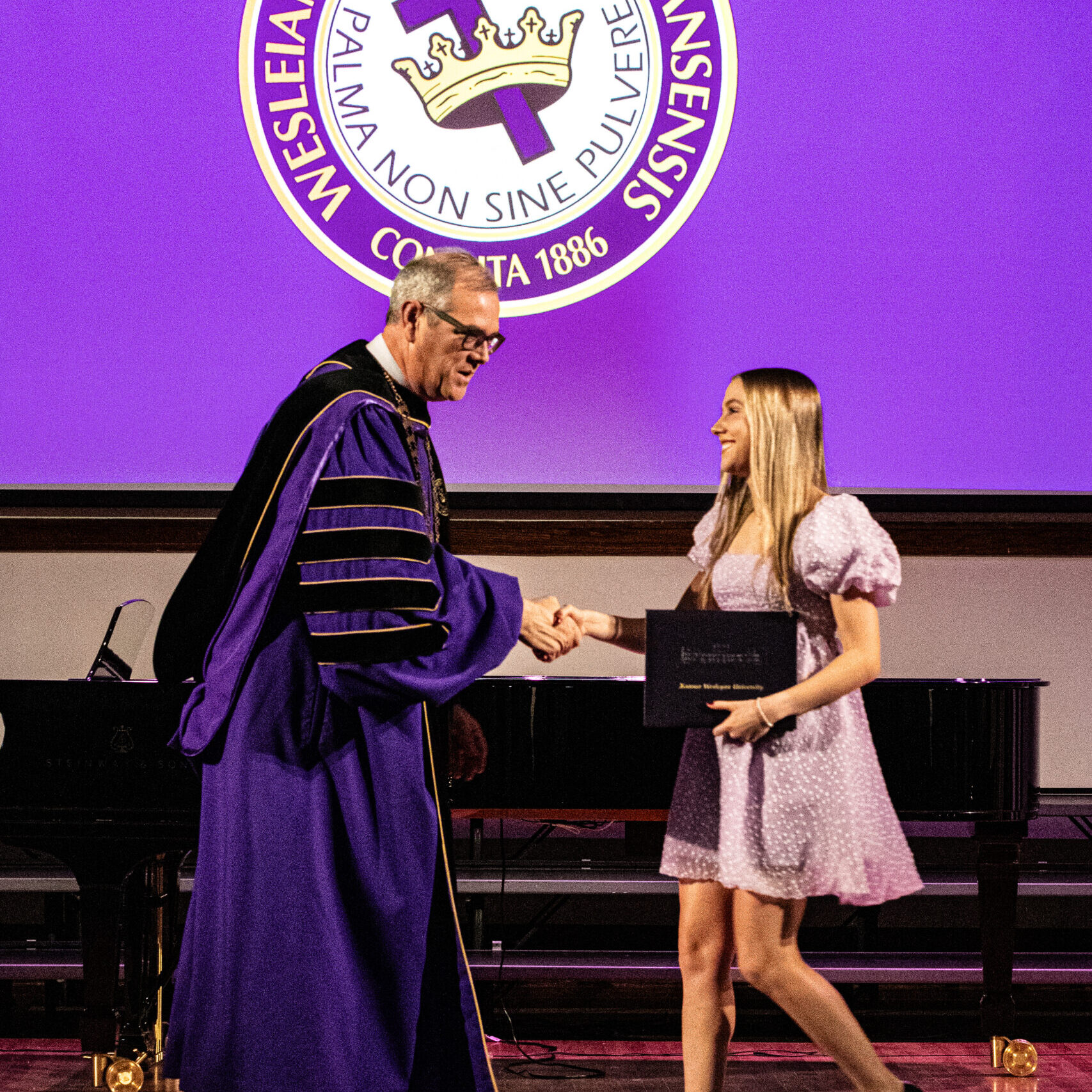 Female graduate shaking hands with president