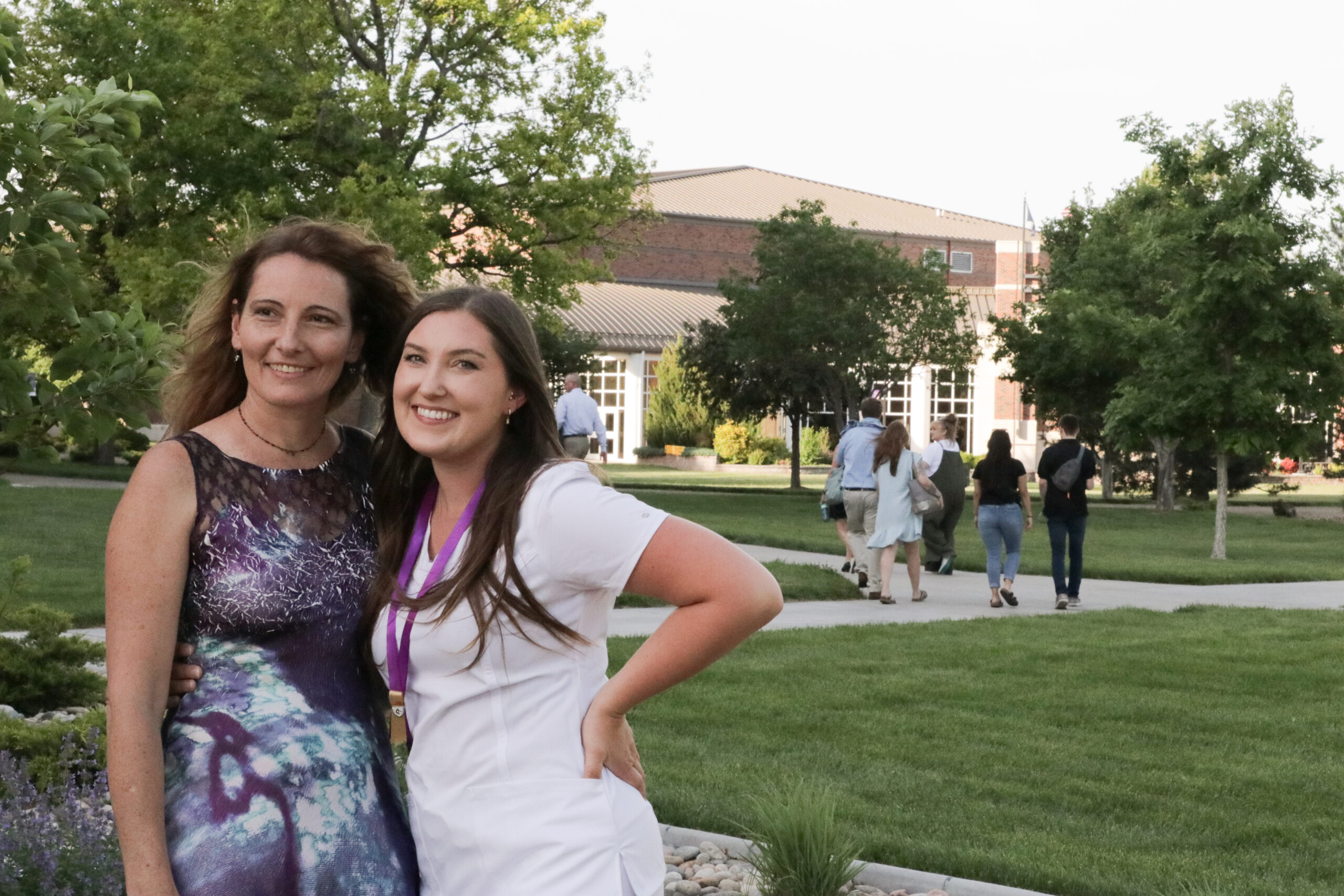 Two women with landscape behind posing - one in Nursing gear
