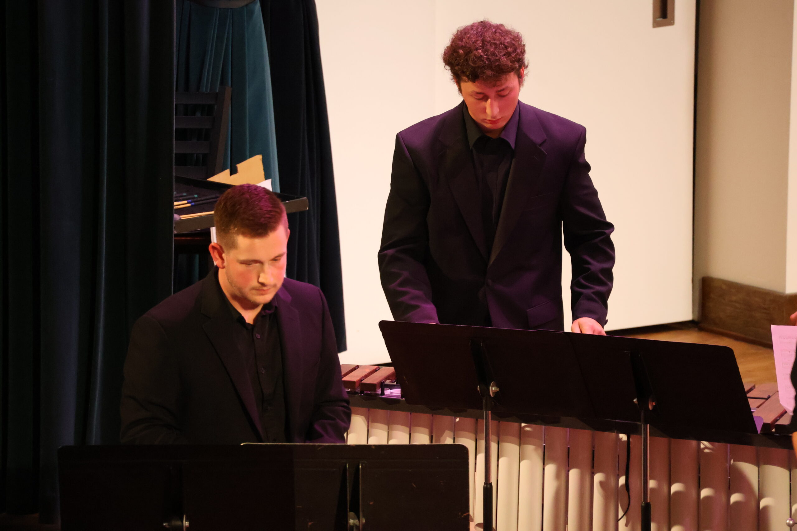 Two men playing percussion, one in front of the other
