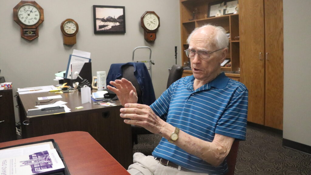 Man gesturing while sitting in chair talking