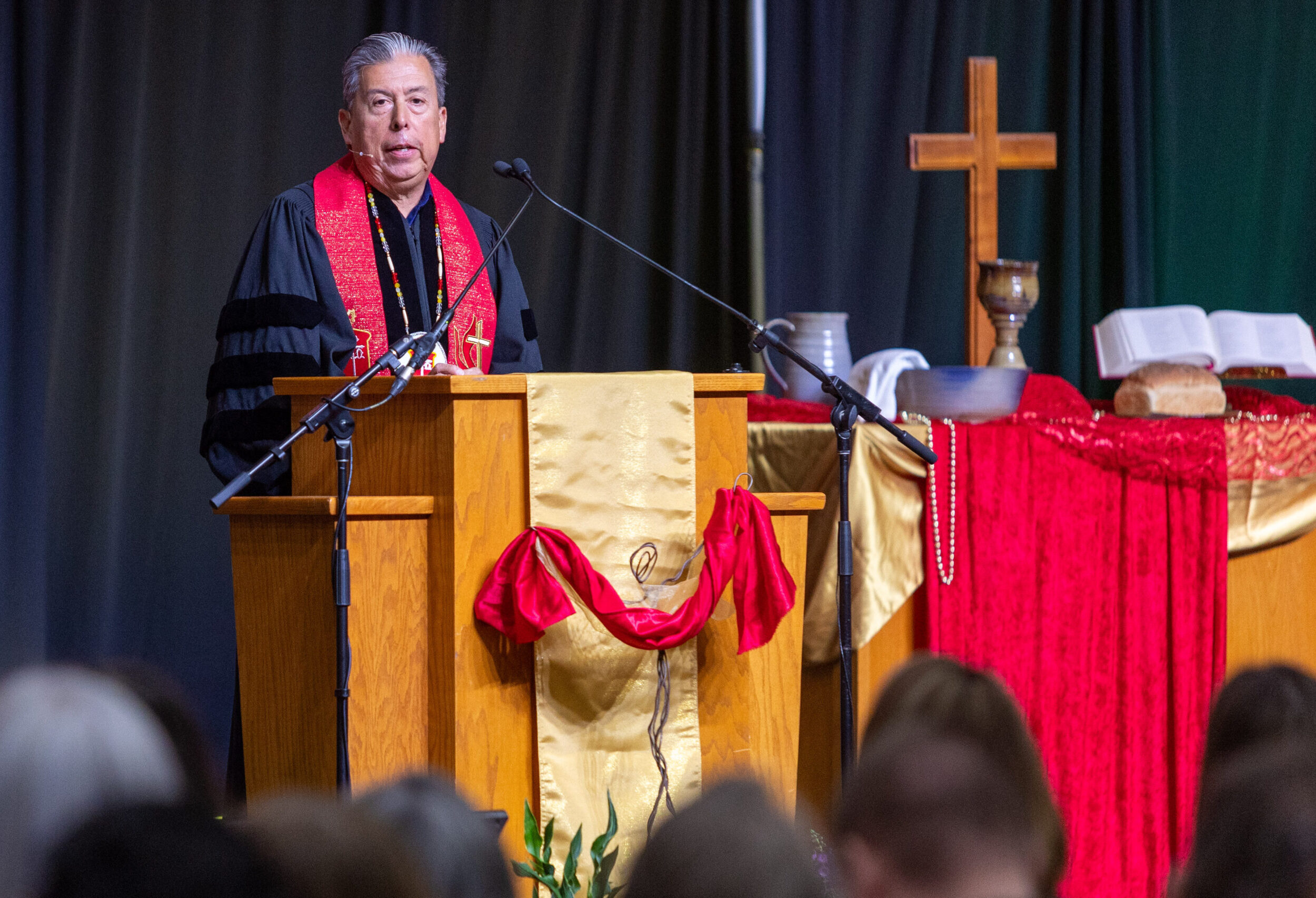 Man in clergy robes at podium speaking